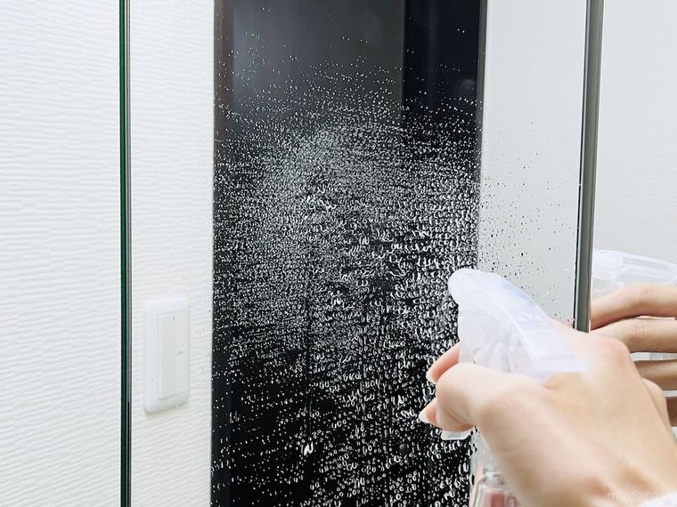 洗面台の鏡に気の抜けた炭酸水を吹きかけている様子