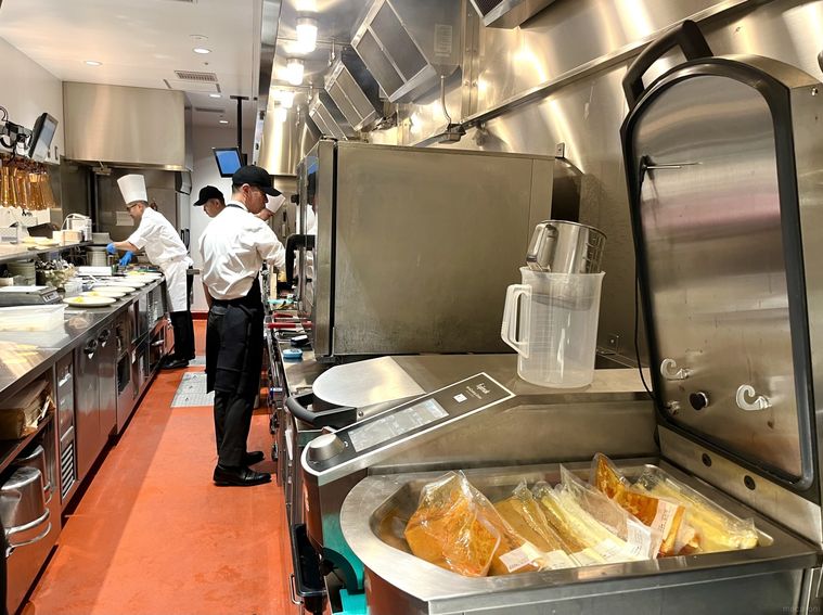 セントラルキッチンで調理・パッキングされたカレーやスープなどがある、キッチン内部の様子