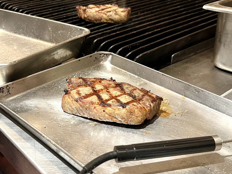 手切りしたリブロース肉をチャーブロイラーで直火焼きしている様子