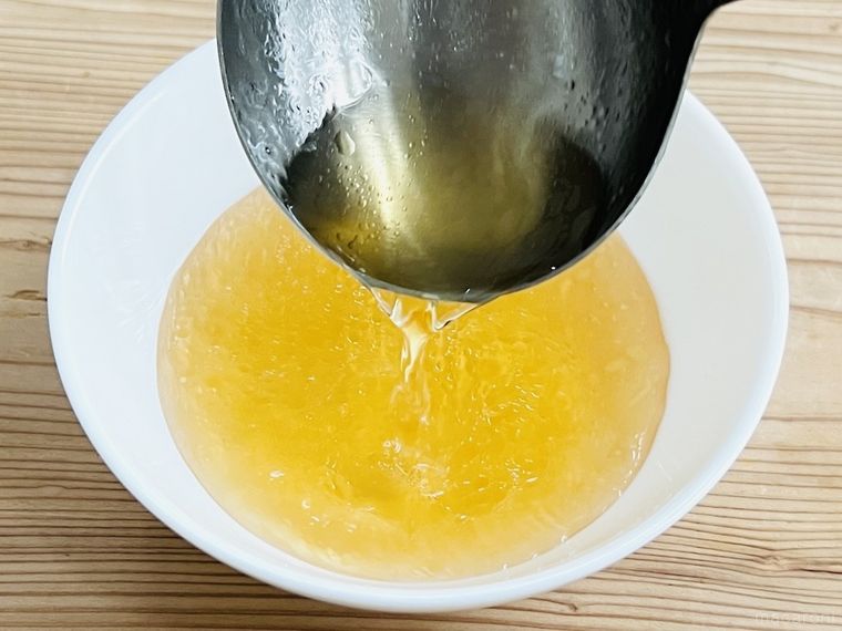 油が浮いたスープを器によそっている様子