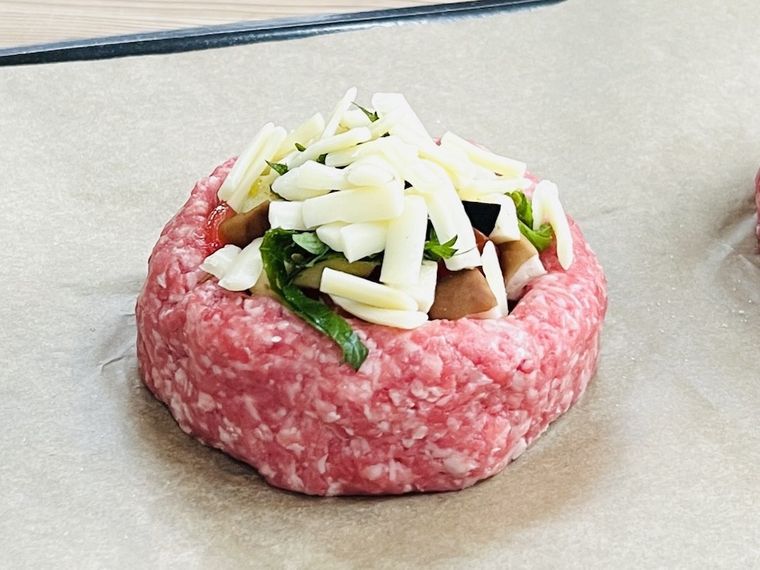 器状に成形した肉ダネにチーズをのせた様子