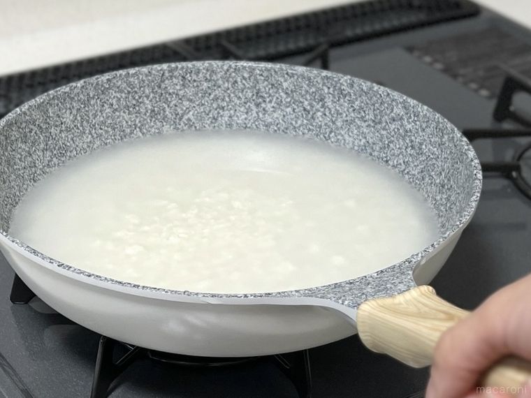 米とお湯が入ったフライパンを揺すっている様子
