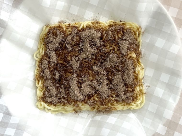 焼きそば麺に酒と粉末ソースをかけた様子
