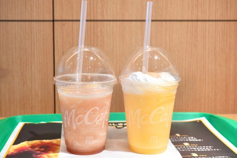 緑色のトレーにのったプラカップ入りの桃味のスムージーとミックスフルーツ味のフラッペ