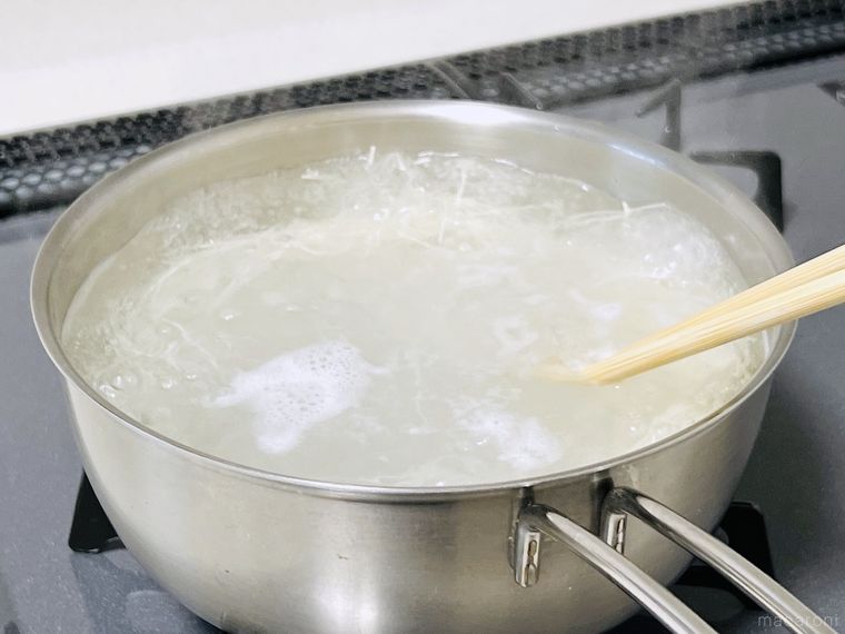 沸騰したお湯にそうめんを入れてほぐしている様子