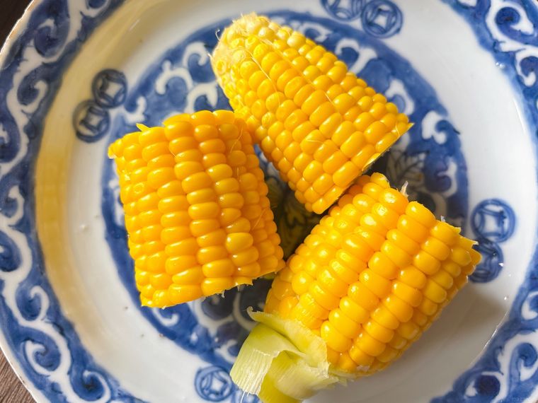 和皿に盛られたフライパンで蒸したとうもろこし
