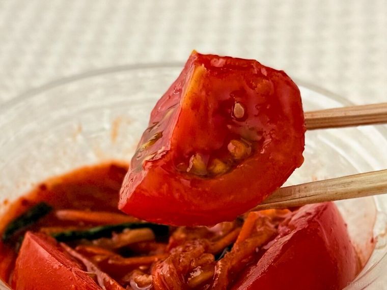 トマトキムチのトマトを箸で持っている様子