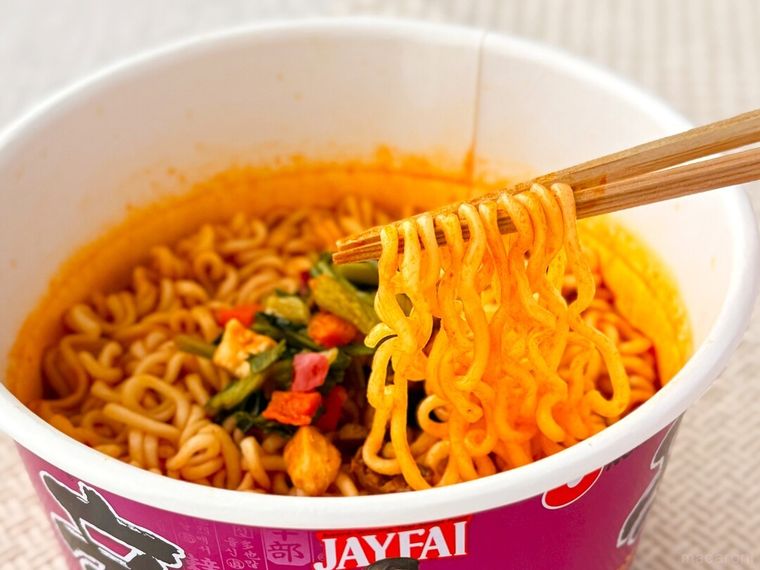 辛ラーメン トムヤムクン カップの麺を箸で持っている様子