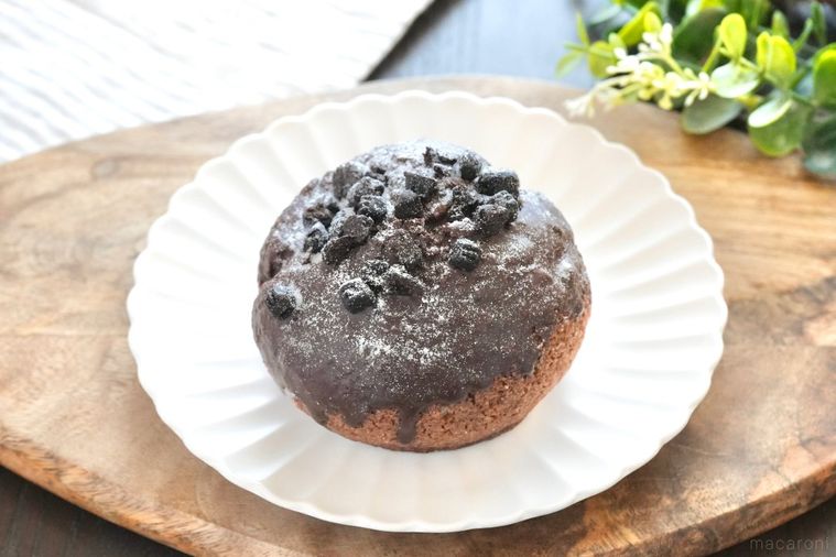 木のカッティングボードと白い皿にのったクッキーアンドクリーム味のシュークリームとストライプの布とグリーン