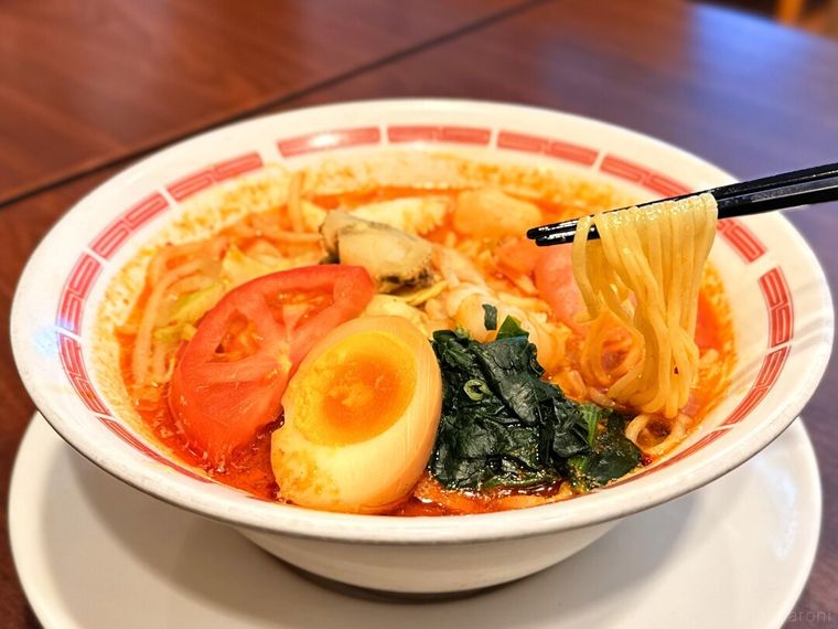 「蟹小籠包入り！海鮮麻辣湯（マーラータン）」の中華麺を箸で持っている様子