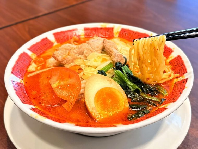 「豚肉もやしのスタミナ麻辣湯（マーラータン）」の中華麺を箸で持っている様子