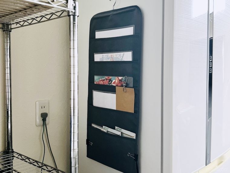 書類を入れた吊り下げシャツ収納を冷蔵庫わきに設置した様子