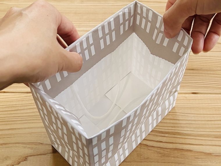 紙袋の上部を内側に折り込んでいる様子
