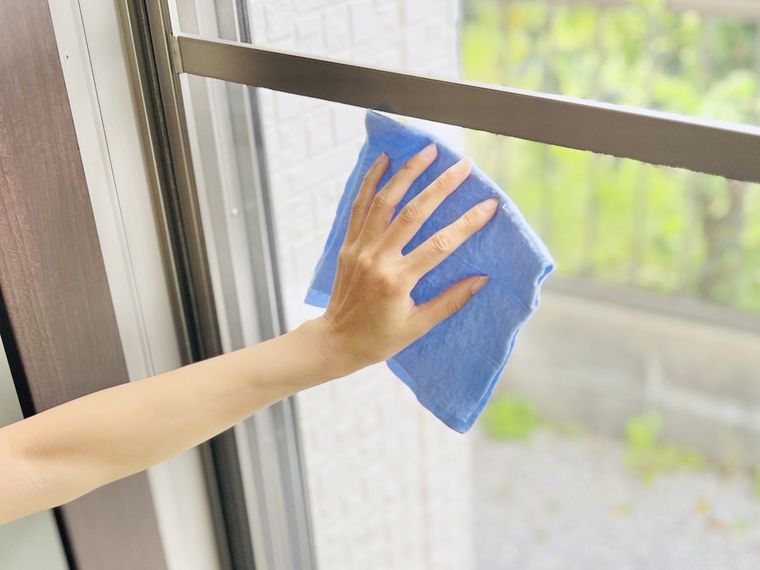 柔軟剤を含ませた布で網戸を拭いている様子