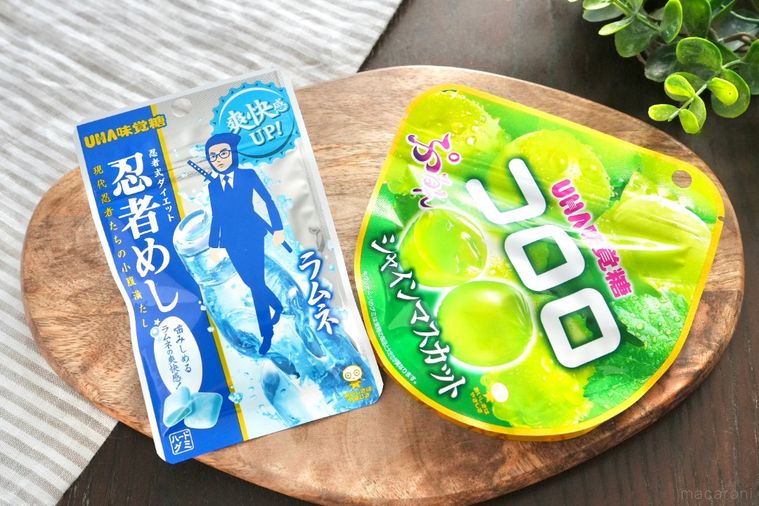 グリーンとストライプの布と木のカッティングボードにのったグミ