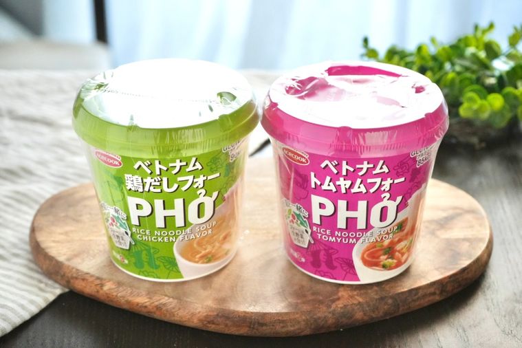 グリーンとストライプの布と木のカッティングボードにのったカップ麺