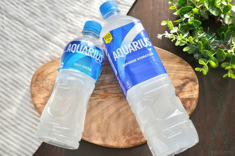 グリーンとストライプの布と木のカッティングボードにのったペットボトル飲料