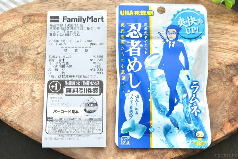 木のカッティングボードにのった青いパッケージのグミとコンビニのレシート