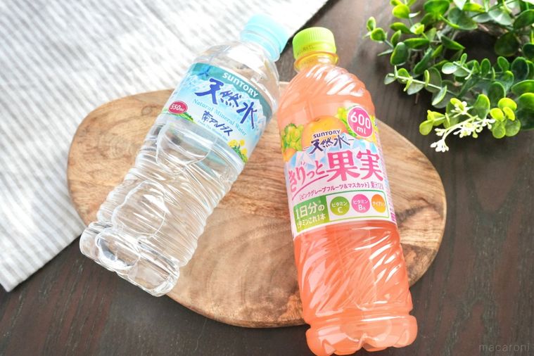 グリーンとストライプの布と木のカッティングボードにのったペットボトル飲料