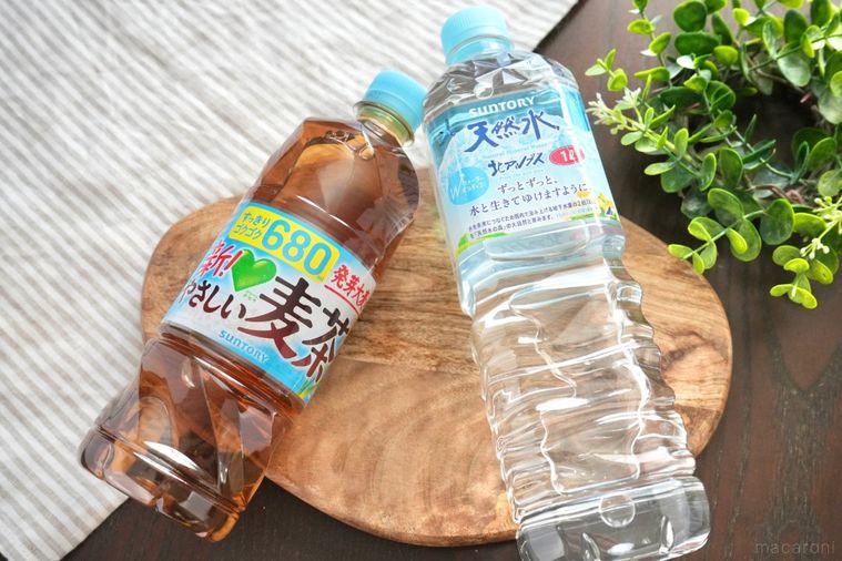 グリーンとストライプの布と木のカッティングボードにのったペットボトル飲料