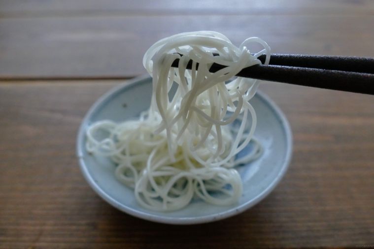 オリーブオイルを絡めたそうめんを箸で持ち上げる様子
