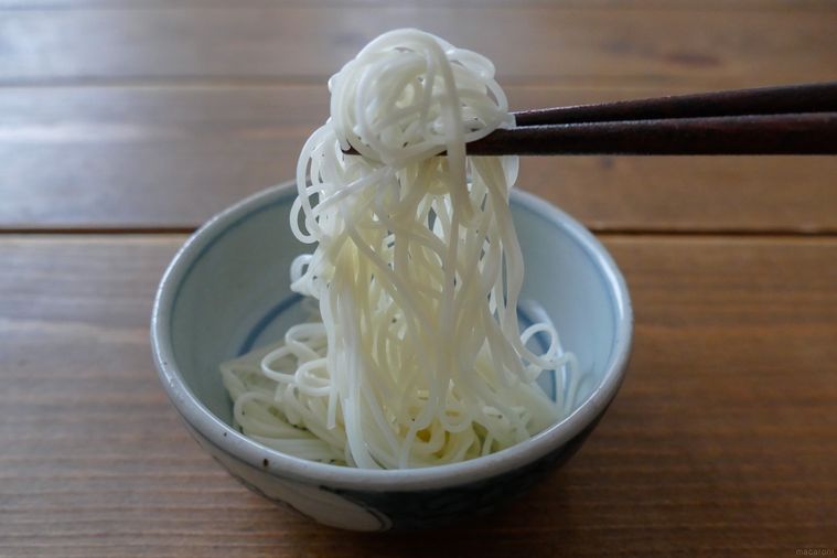 ごま油を絡めて6時間置いたそうめんを箸で持ち上げる様子