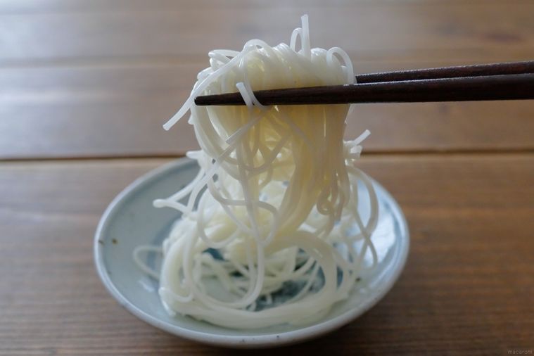 サラダ油を絡めて6時間置いたそうめんを箸で持ち上げる様子
