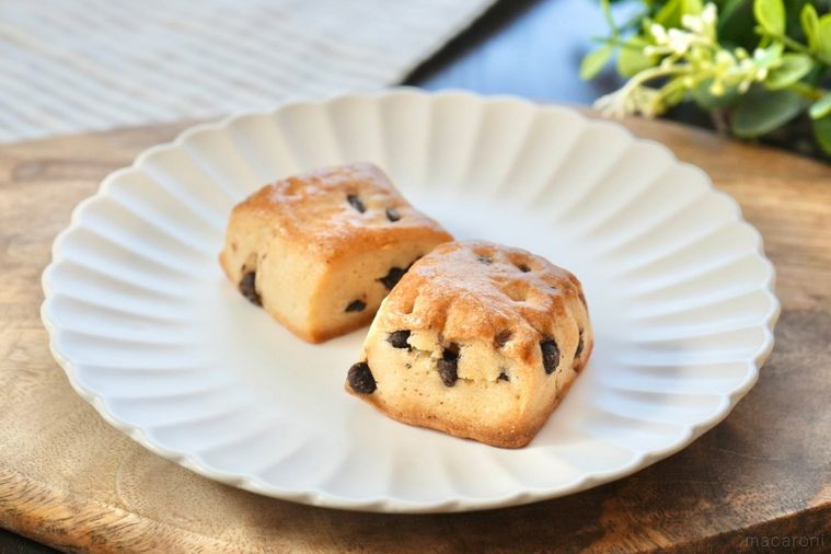 木のカッティングボードと白い皿にのったチョコチャンクスコーンとストライプの布とグリーン