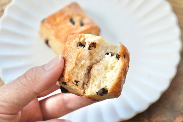 木のカッティングボードと白い皿にのったチョコチャンクスコーンの断面と手に持つ様子