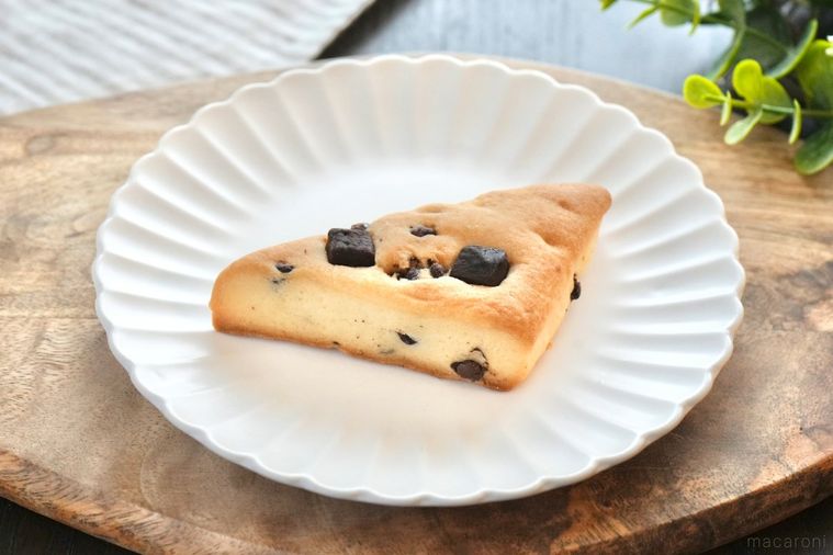 木のカッティングボードと白い皿にのったチョコチップスコーンとストライプの布とグリーン