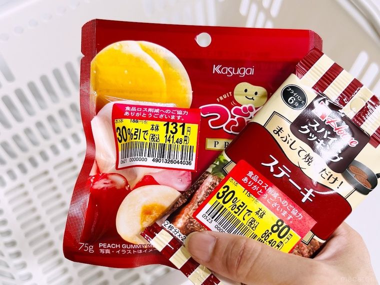 割引シールが付いたグミとスパイスを買い物カゴに入れようとしている様子