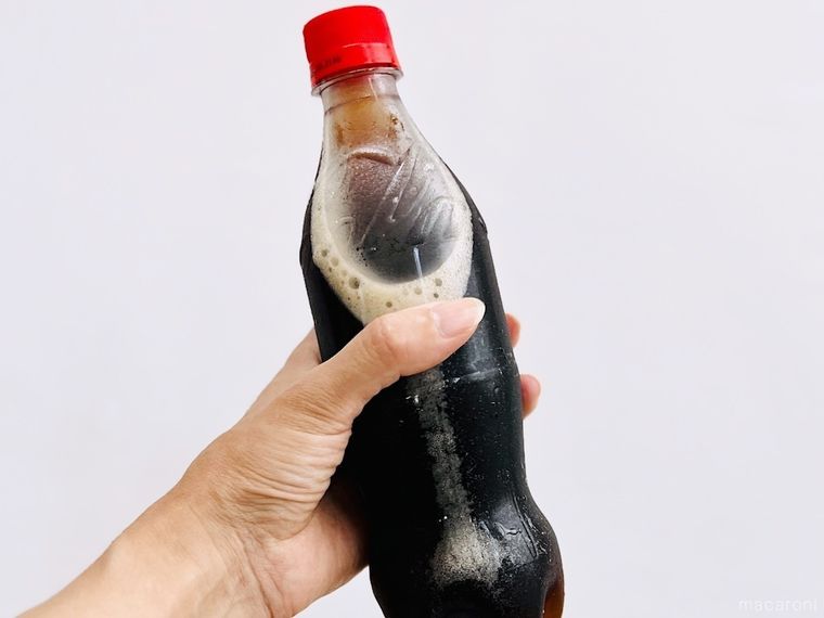 コーラが入ったペットボトルを手で持っている様子