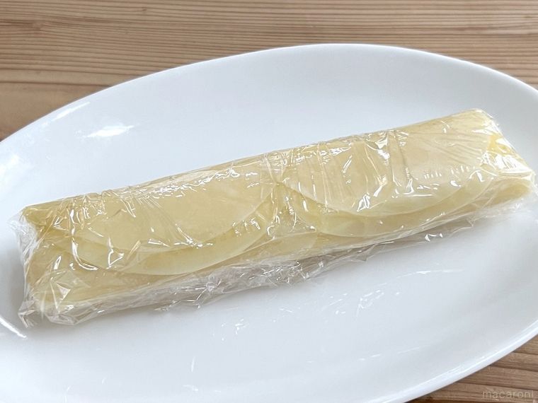 筒状に巻いた餃子の皮をラップで包んだ様子