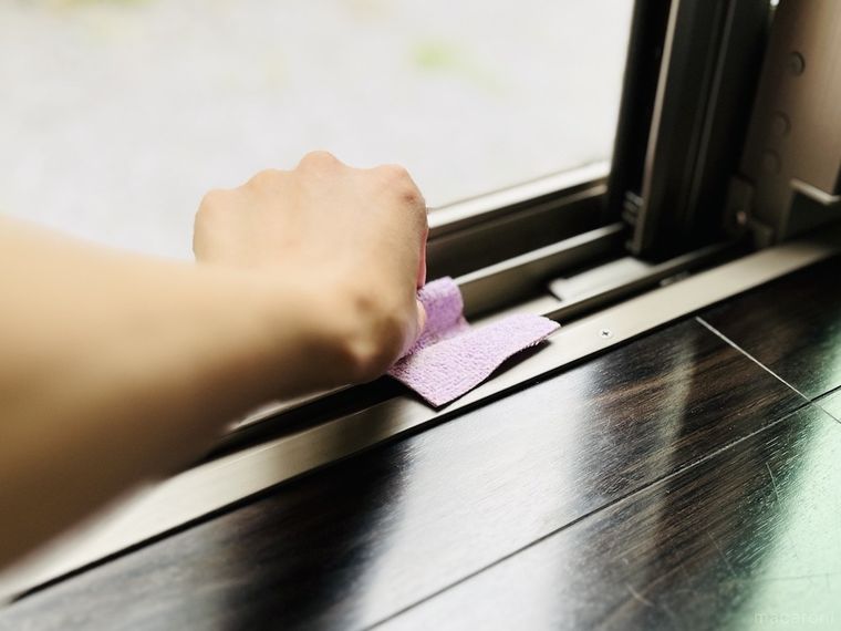 剥がした驚吸水おそうじスポンジで窓のレールを掃除している様子