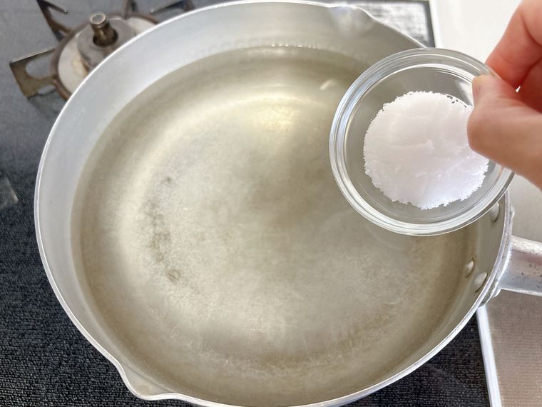 鍋に塩を入れる様子