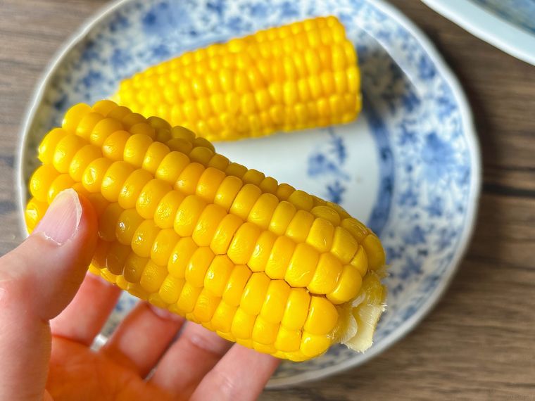 甘くする方法を試したとうもろこしを手に持った様子
