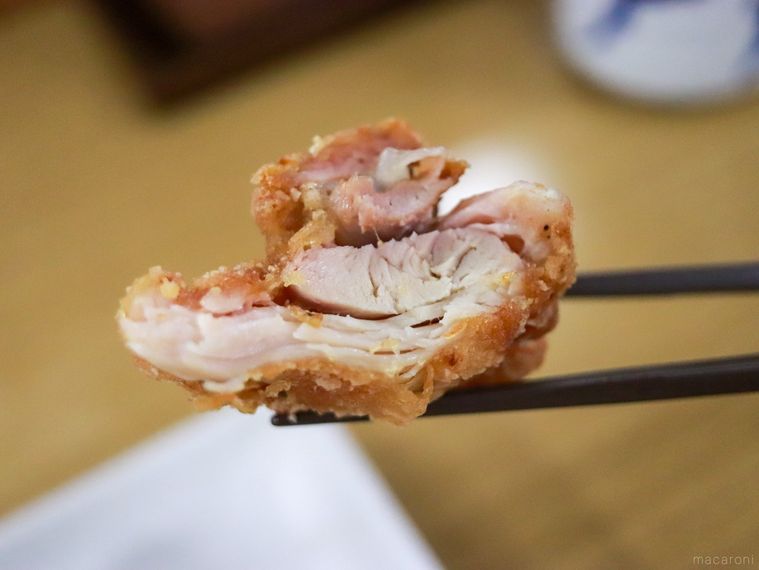 おにぎり2つセットに付いてくる唐揚げ「戸越丸」を箸上げしている