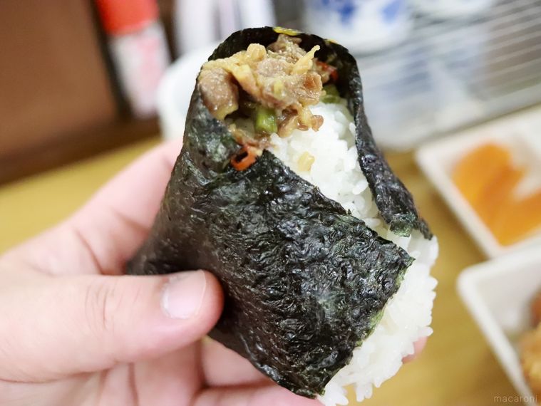 米がおいしいおにぎり戸越屋 戸越銀座本店のおにぎり「牛甘辛わさび」を手に持っている様子