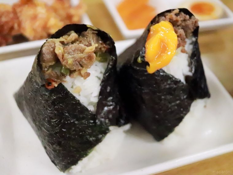 長方形の白いお皿に並んでいる「牛甘辛わさび」と「卵黄＋肉そぼろ」のおにぎり