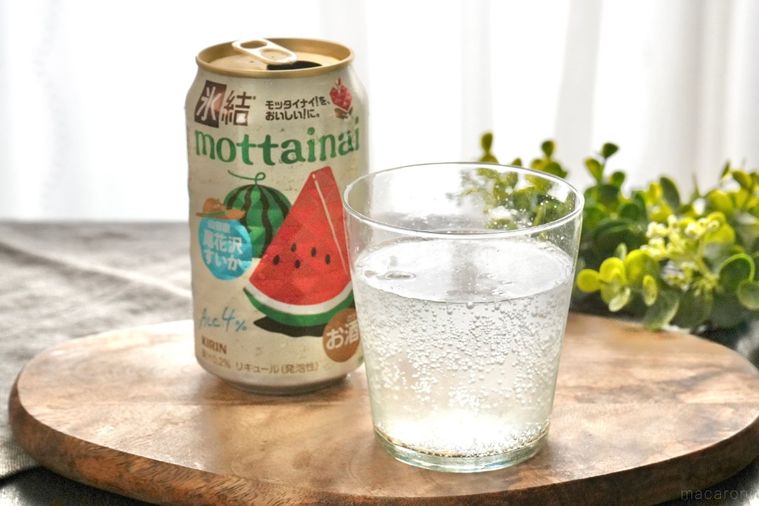 木のカッティングボードにのったグラスに注がれた尾花沢すいかの缶チューハイ