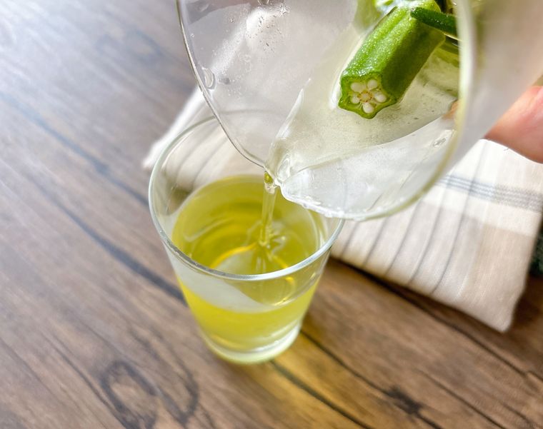 オクラ茶をグラスに注ぐ様子