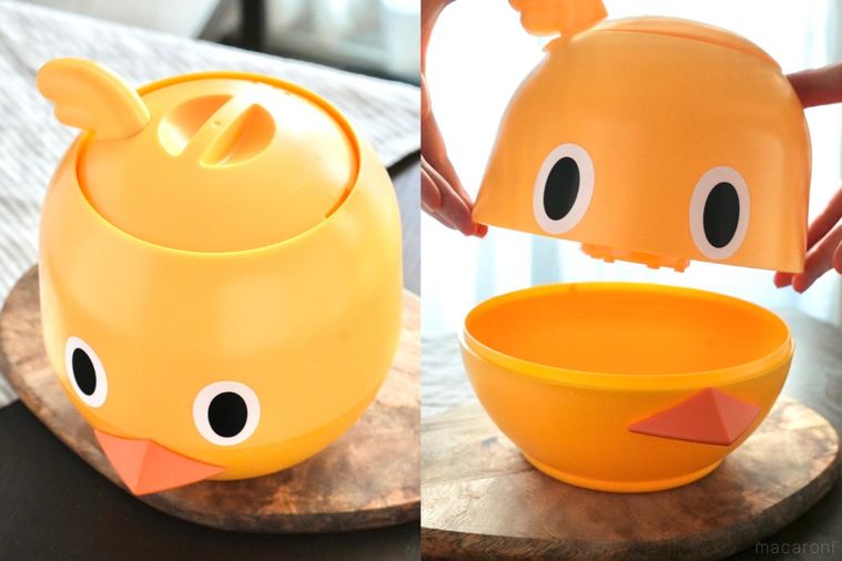 木のカッティングボードにのったひよこ型のラーメンどんぶりガジェットとストライプの布