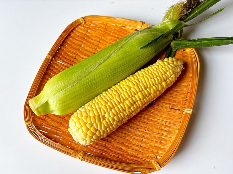 ザルに盛られたとうもろこしの皮なしと皮あり
