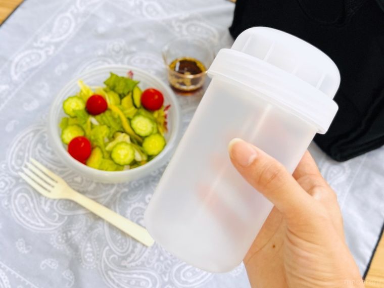 サラダが入った保存容器と、無印良品のトッピングカップ付き ランチカプセル