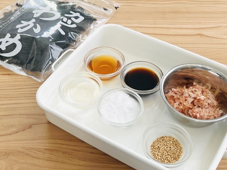 カットわかめ、ごま油、しょうゆ、みりん、砂糖、かつおぶし、白いりごまが置かれている