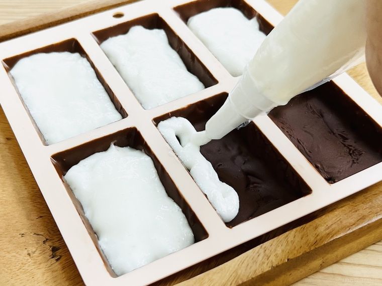 チョコレートが入った型にぬりまろを絞り出している様子