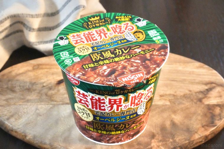 木のカッティングボードにのった緑色のパッケージのカレーカップメシ