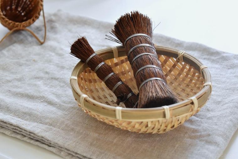 ざるにのせたシュロの棒たわし2種