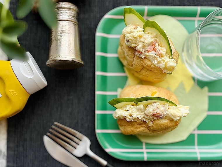 緑色のトレイ、コストコのコーンブレッドロールにポテトサラダときゅうりを挟んだサンドイッチ、カトラリー、スパイス