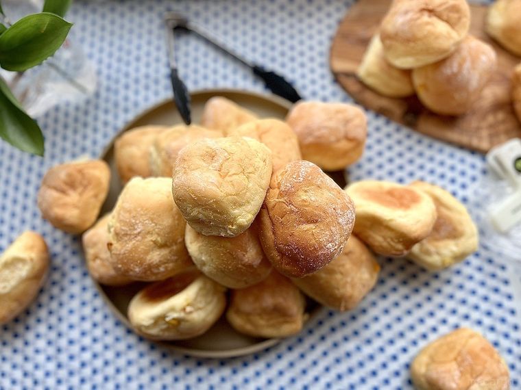 青いドット柄のテーブルクロスに置いたプレートに溢れるほど盛り付けたコストコのコーンブレッドロール